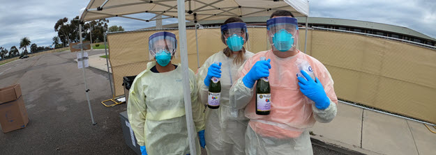 Three responders in PPE with sparkling cider