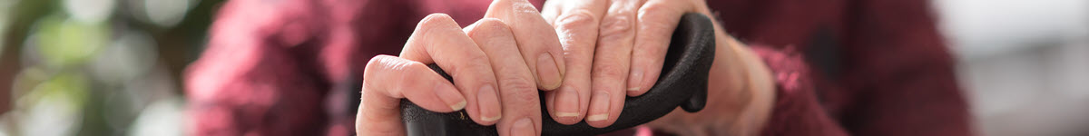 Photo of elderly person's hands holding a walking cane