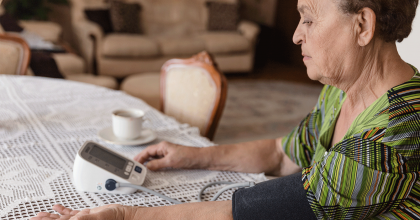Senior adult woman measuring blood pressure at home.