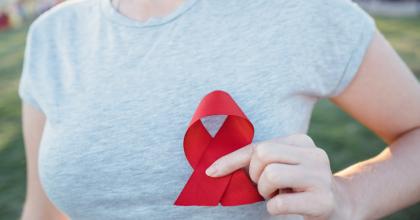 Woman holding ribbon for HIV/AIDS awareness month 