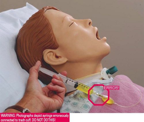 Syringe erroneously connected to trach cuff on a mannequin.