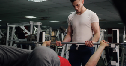 Image of two men using weight-lifting equipment