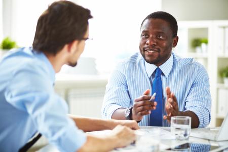 Two men at table talking