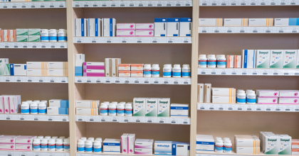 Close up image of shelves stocked with a variety of prescription medications.