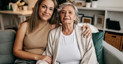 Image of Mother and adult daughter sitting on couch