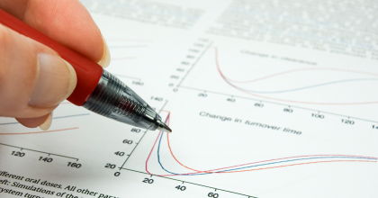 Person writing on a scientific manuscript article with a pen