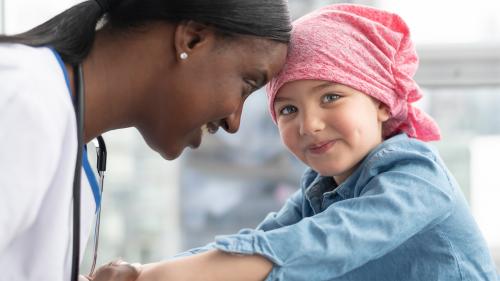 pediatric cancer patient and doctor holding hands and smiling