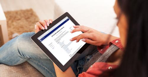 Woman reading a tablet displaying FDA web page about HIV and AIDS medicines