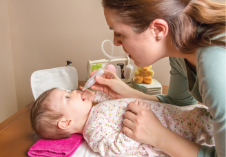 Mother administering medicine to an infant