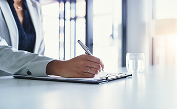 Person writing on a clipboard – Getty Image