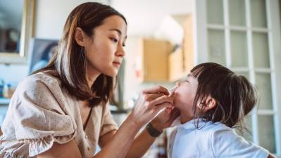 Woman performing a COVID-19 test on a child