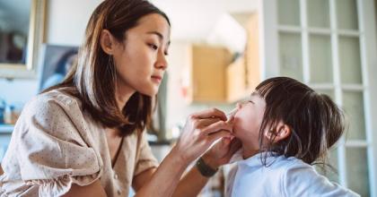 Woman performing a COVID-19 test on a child