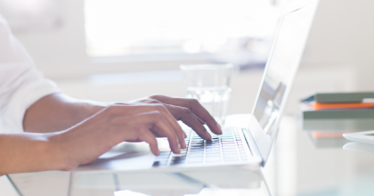 Image of businessperson typing on a laptop