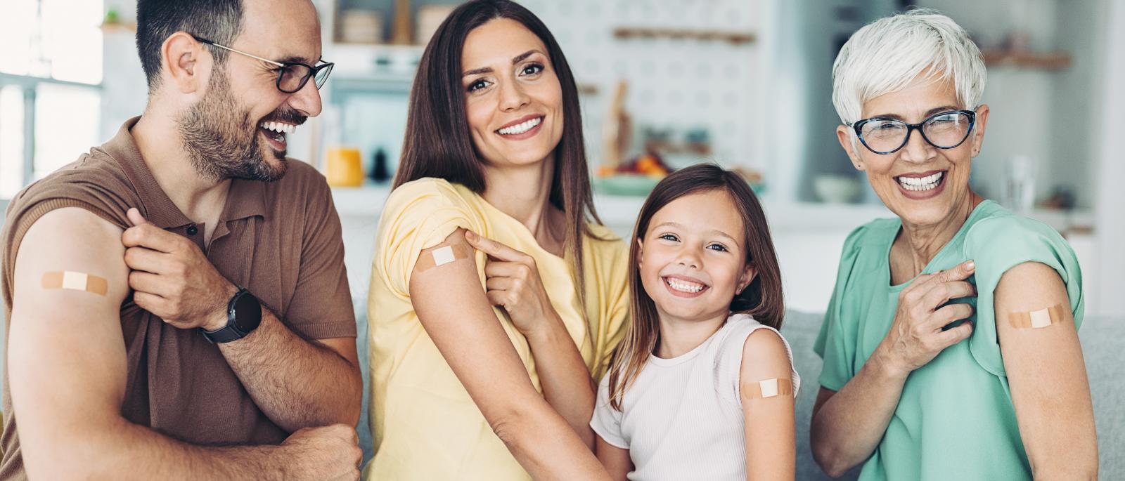 Family showing off bandages from receiving a vaccination 