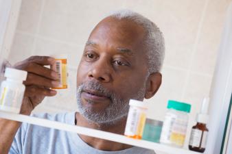 Man looks at Prescription Bottle.