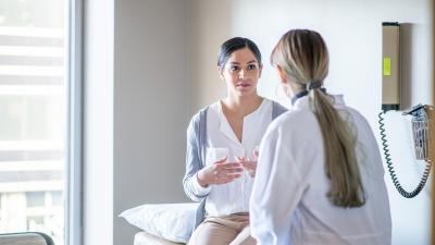 Woman discussing prenatal screening with a doctor.