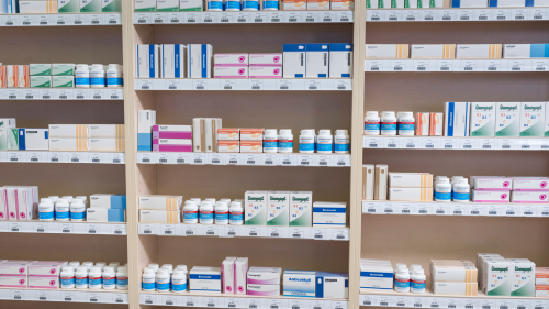 Close up image of shelves stocked with a variety of prescription medications.