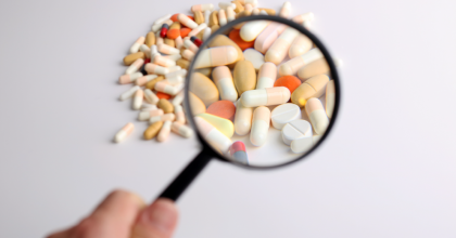 Magnifying Glass held over a pile of pills