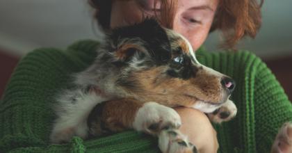 Photo of a woman hugging a dog.