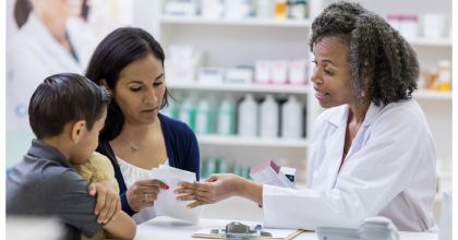 Pharmacist talking with mother and child 