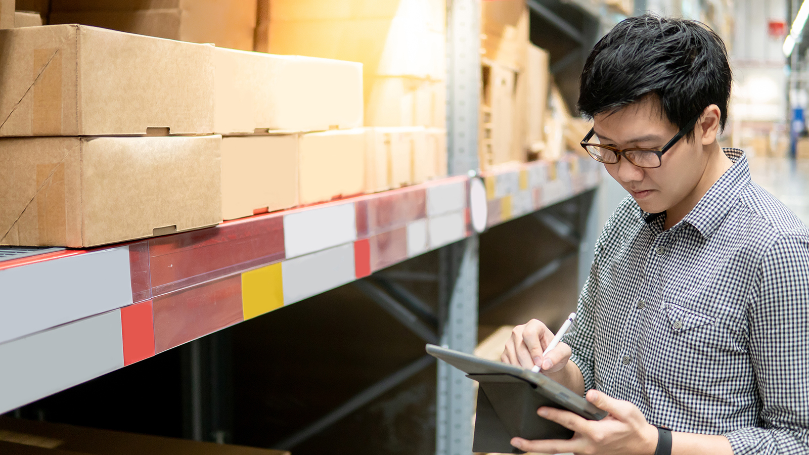 man in a warehouse checking inventory with a digital tablet 