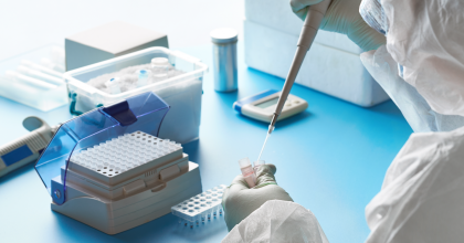 Lab technician wearing full body protection running tests in lab.