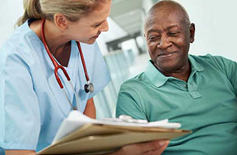 Image of an elderly man being handed documents by a female nurse