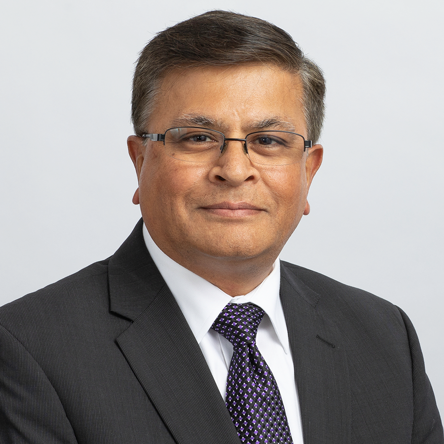 Portrait of Vid Desai, FDA's Chief Technology Officer, wearing a dark suit, dark tie, white shirt, glasses, and smiling while looking at the camera