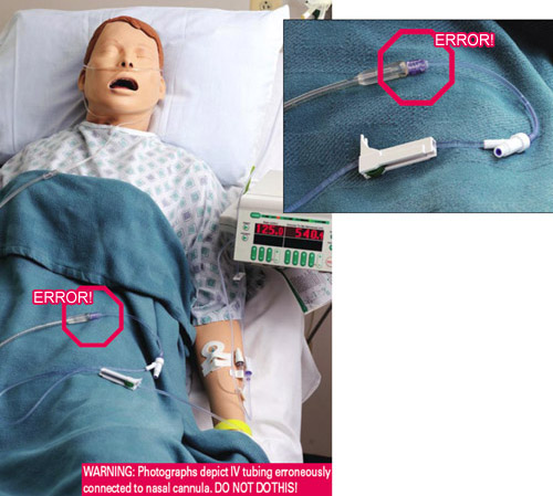 IV tubing erroneously connected to nasal cannula on a mannequin in a hospital bed.