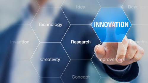 photo of man touching the word INNOVATION with his index finger on a screen with other words on it: Development, Improvement, Experiment, Concept, Research, Idea, Creativity, Technology, and Invention
