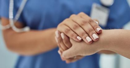 Closeup shot of a nurse holding a patient's hand in comfort in a hospital