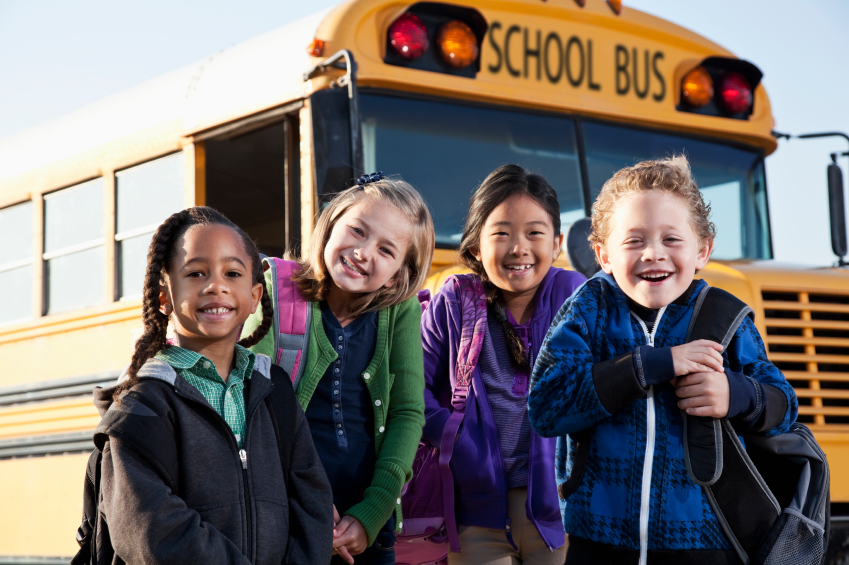 Children standing in front of school bus.