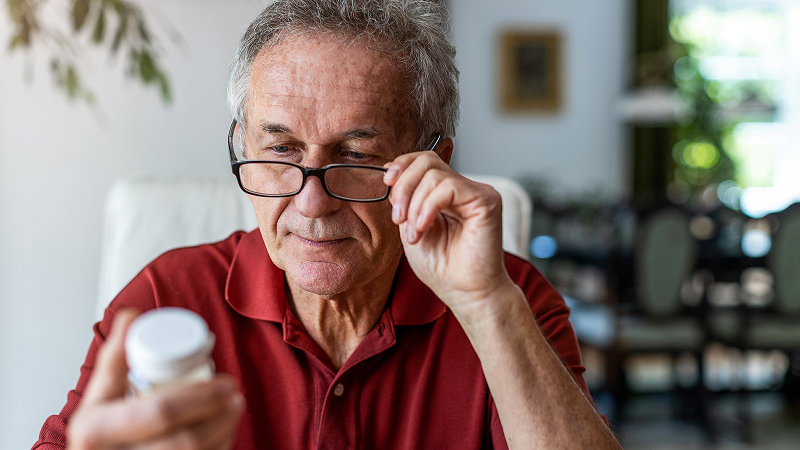 Man reading bottle of medicine