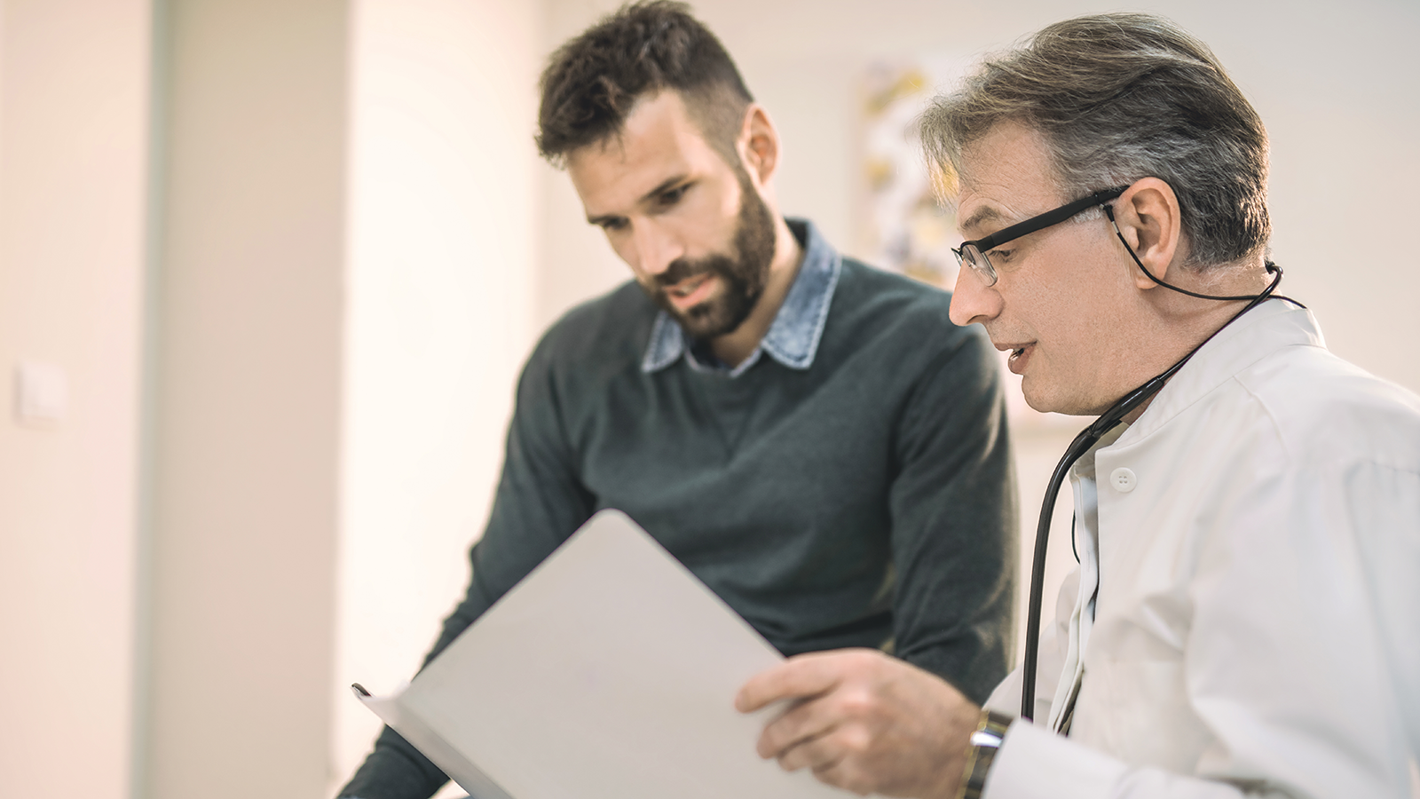 Doctor looking at a  folder talking to a patient