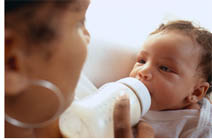 Woman feeding a baby with a bottle.