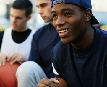 Young men sitting with basketball