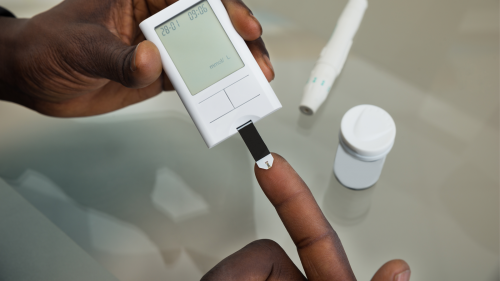 Male hands holding Glucose Meter.