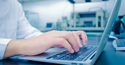 Doctor typing on a laptop in a laboratory