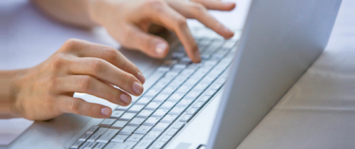 hands typing on a computer keyboard