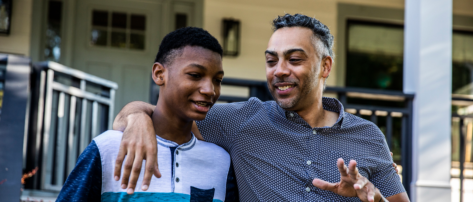 Man talking and smiling with teenage boy