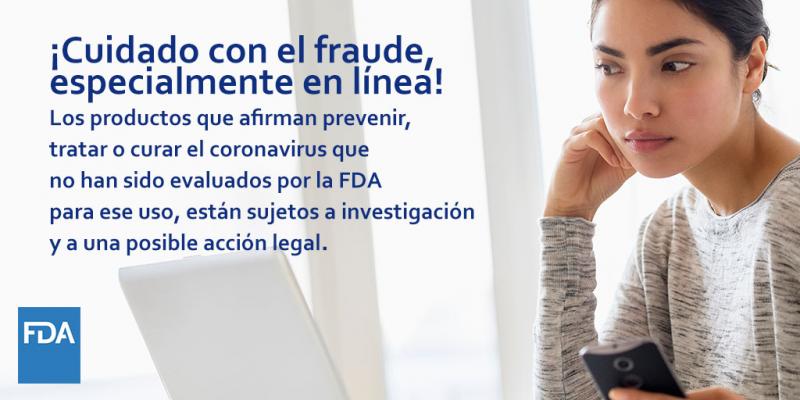 Mujer navegando en la computadora con celular en mano. ¡Cuidado con el fraude, especialmente en línea! Los productos que afirman prevenir, tratar o curar el coronavirus que no han sido evaluados por la FDA para ese uso están sujetos a investigación y a una posible acción legal. 