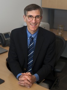 Peter Marks smiling while sitting at desk. 