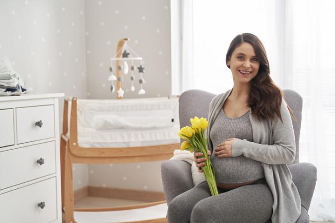 Portrait of caucasian woman in advanced pregnancy holding yellow tulips