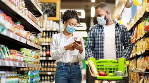 Couple reading label of food product inside grocery store