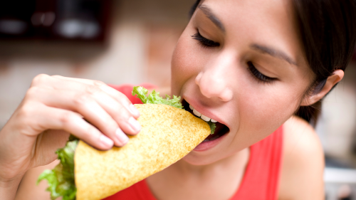 Latina eating corn masa tortilla