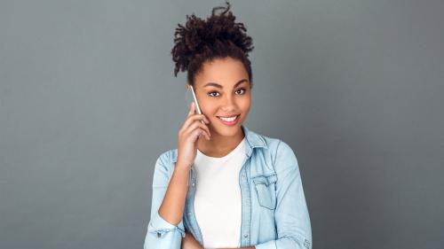 Teenage girl holding cell phone to her ear and smiling. Children and Teens and Cell Phones.