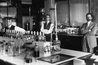 Three men in a laboratory (L to R): Rex Shiveley, L.B. Mears, and W.O. Emery