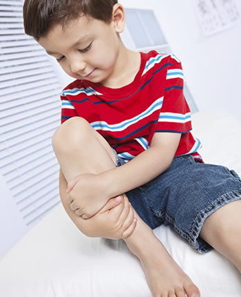 boy in clinic holding knee (350x430)