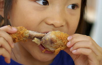young girl eating fried chicken (350x224)