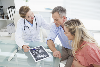 Parents looking at an ultrasound with a doctor